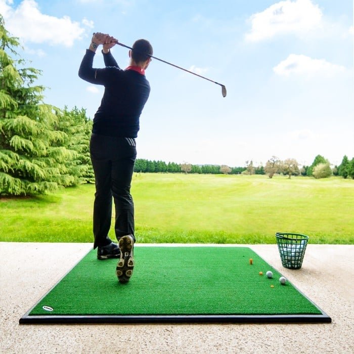 A man swinging his club at a driving range